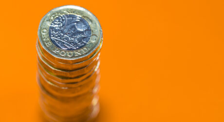 Stacked Pound Coins with orange backdrop
