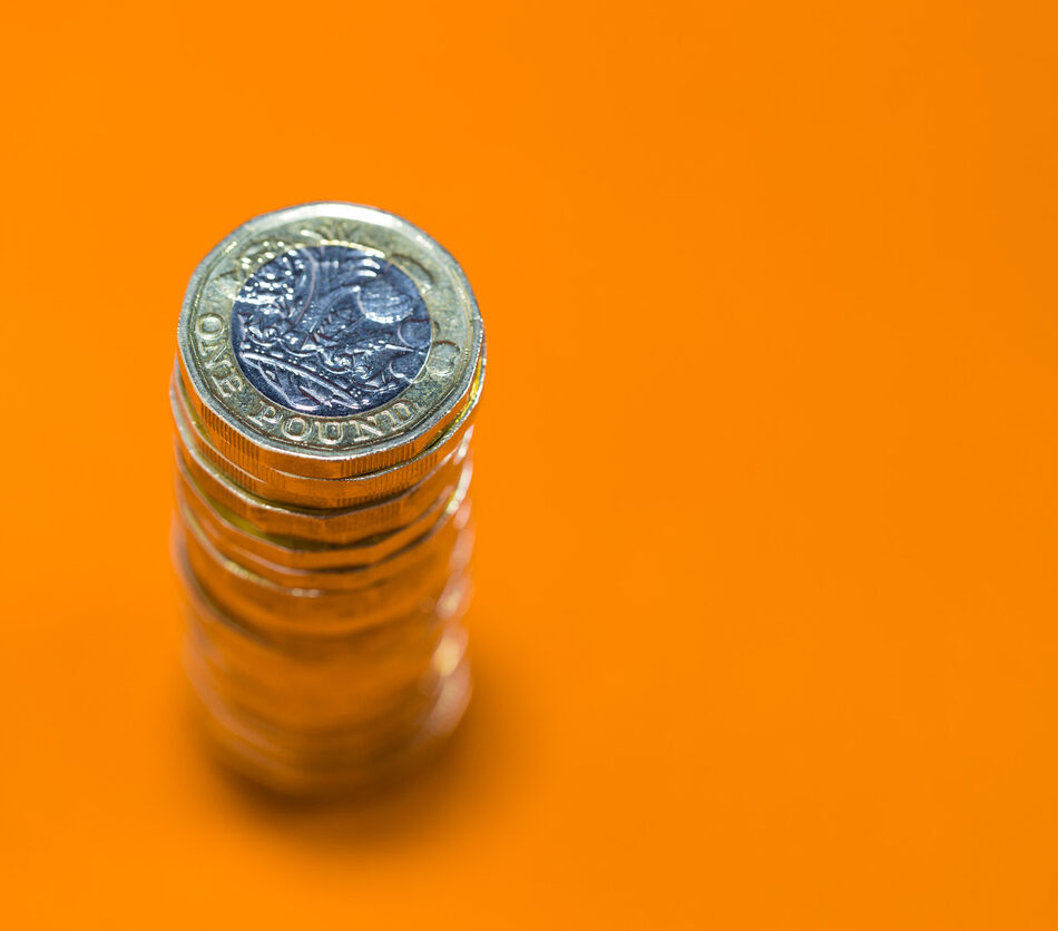 Stacked Pound Coins with orange backdrop